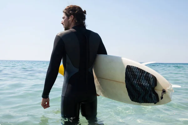 Surfer z deski surfingowej patrząc na morzu — Zdjęcie stockowe
