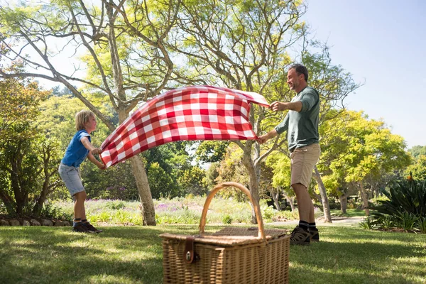 Ojciec i syn rozprzestrzeniania koc piknikowy — Zdjęcie stockowe