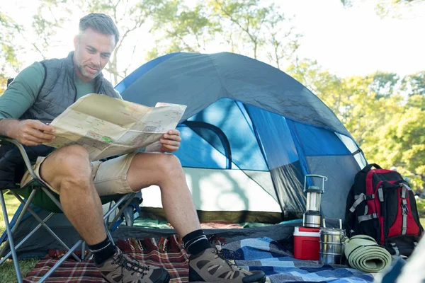 Man reading the map outside the tent — Stock Photo, Image