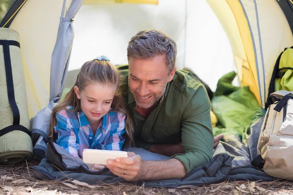 Père et fille utilisant le téléphone au camping — Photo