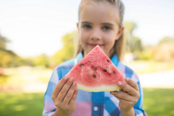 Flickan håller vattenmelon bit i parken — Stockfoto