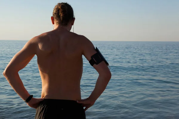 Muskulös man ute till havs från stranden — Stockfoto