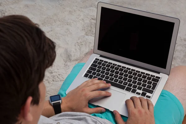 Mann benutzt Laptop am Strand — Stockfoto