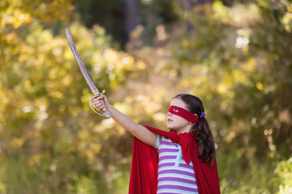 Chica sosteniendo espada mientras usa traje de superhéroe — Foto de Stock