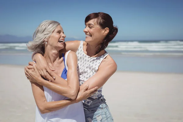 Donna con sua madre in piedi in spiaggia — Foto Stock