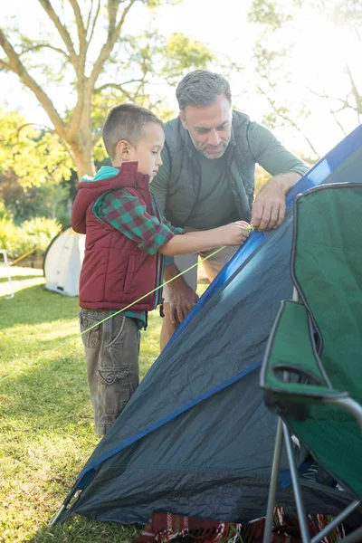 Padre e figlio allestiscono una tenda al campeggio — Foto Stock