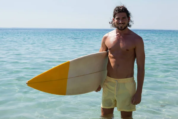 Surfer mit Surfbrett steht am Strand — Stockfoto