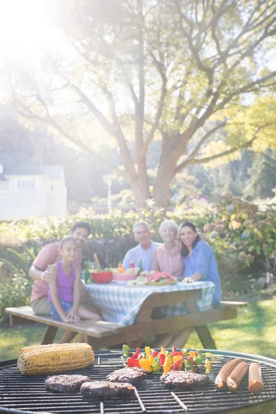 Barbecue et famille assis sur la table — Photo