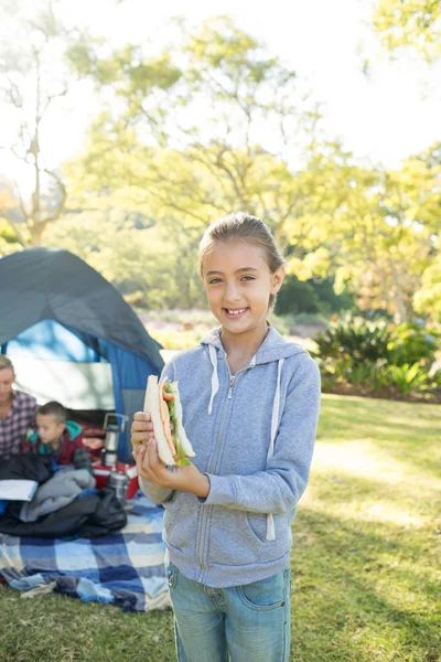 Ragazza che tiene panino al campeggio — Foto Stock