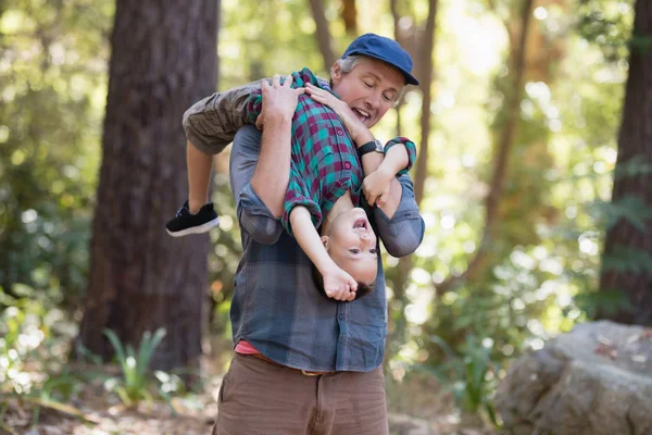 Far bär lille son medan vandring i skogen — Stockfoto