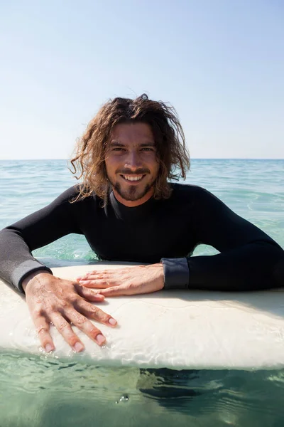 Surfista apoyado en tabla de surf en el mar — Foto de Stock