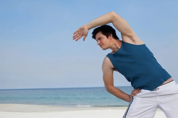 Homem fazendo aquecimento na praia — Fotografia de Stock