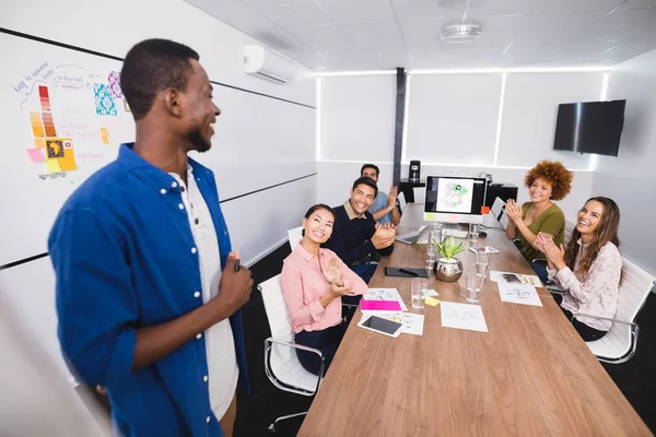 Kollegor som klappar efter presentationen på kreativa kontor — Stockfoto