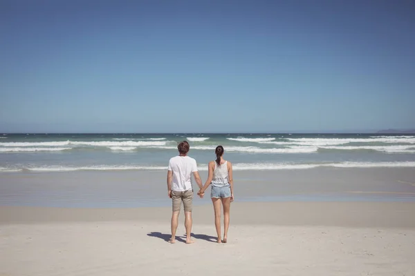 Par hålla händerna på stranden — Stockfoto