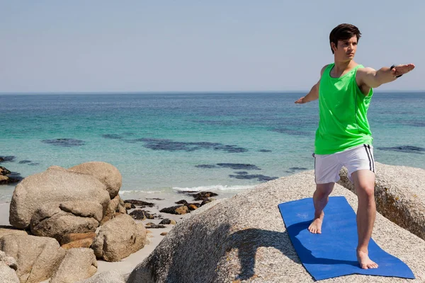 Człowiek, wykonując jogi na skale — Zdjęcie stockowe