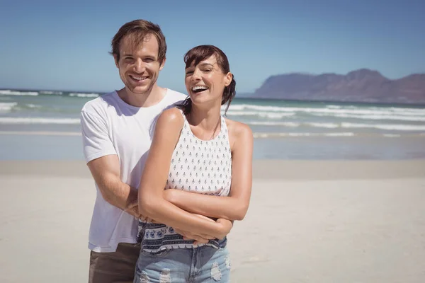 Alegre casal abraçando na praia — Fotografia de Stock