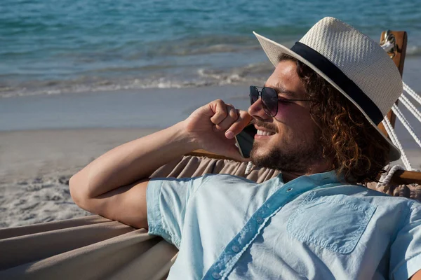 Hombre relajándose en la hamaca y hablando por teléfono — Foto de Stock