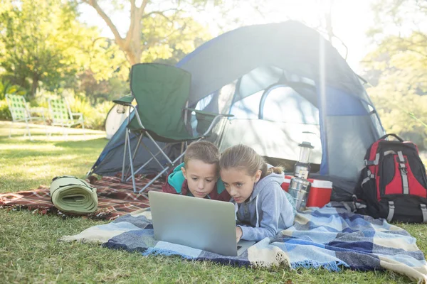 Geschwister mit Laptop außerhalb des Zeltes — Stockfoto