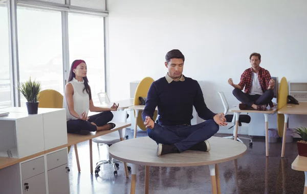 Geschäftskollegen praktizieren Yoga im Büro — Stockfoto