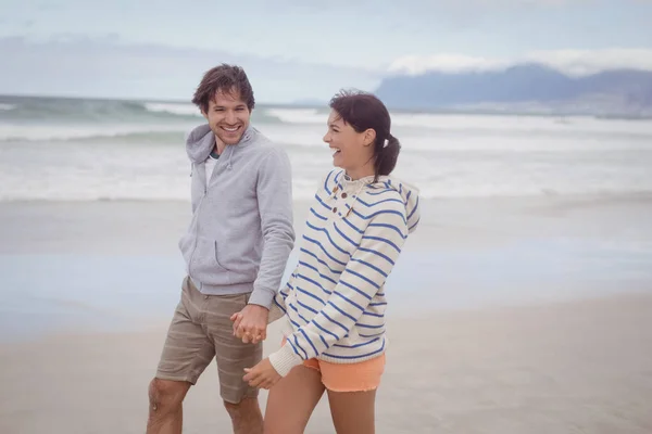 Paar hält Händchen am Strand — Stockfoto
