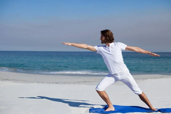 Man utför yoga på stranden — Stockfoto