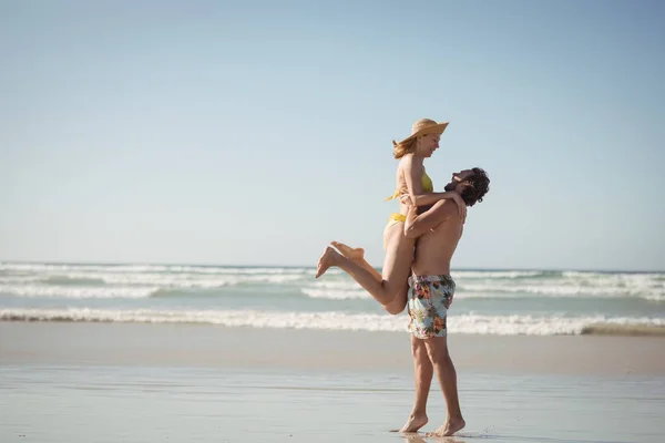 Man lifting woman at beach — Stock Photo, Image
