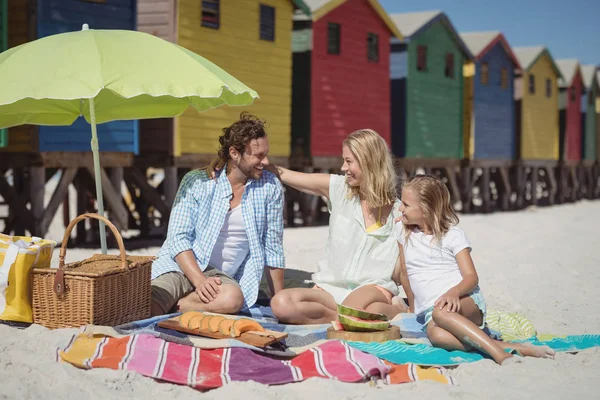 Familjen sitter på filt på stranden — Stockfoto