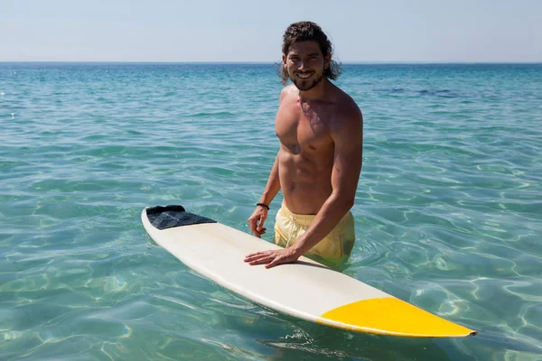 Surfista con tavola da surf in piedi in mare — Foto Stock