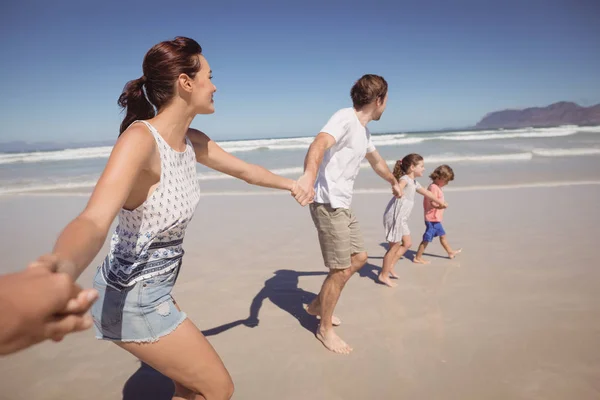 Familie hält Händchen am Strand — Stockfoto