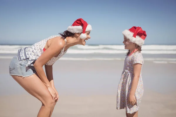 Woman with daughter wearing Santa hat — Stock Photo, Image