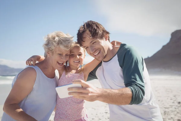 Різногенерована сім'я бере селфі на пляжі — стокове фото