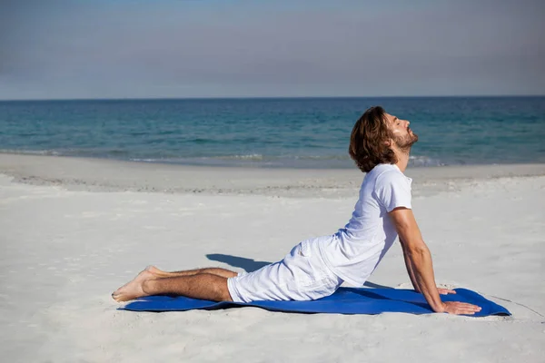 Man utför yoga på stranden — Stockfoto