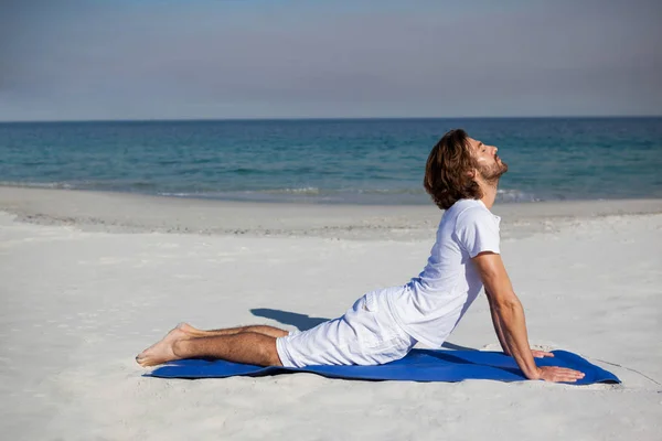 Hombre realizando yoga en la playa — Foto de Stock