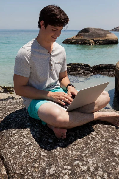 Mann auf Felsen und mit Laptop — Stockfoto