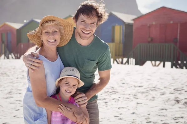 Mehrgenerationenfamilie umarmt sich am Strand — Stockfoto