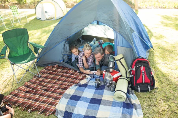Famiglia guardando la fotocamera nella tenda — Foto Stock