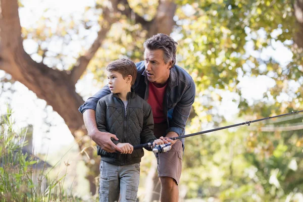 Father and son fishing in forest — Stock Photo, Image