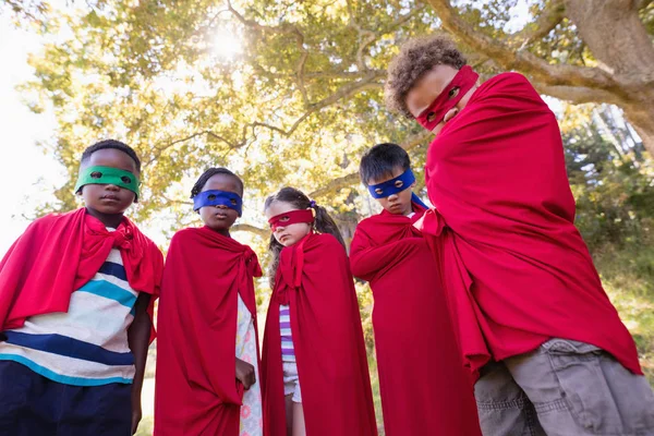 Amigos en trajes de superhéroes de pie en el camping — Foto de Stock