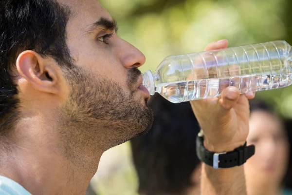 Man dricksvatten i park — Stockfoto