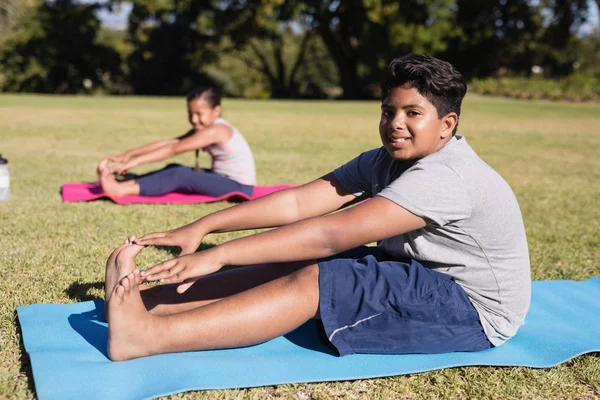 boy touching toes during yoga glass