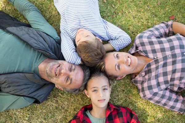 Gelukkig gezin liggend op het gras — Stockfoto