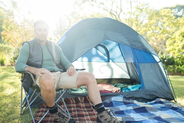 Çadır dışında sandalye üzerinde oturan adam — Stok fotoğraf