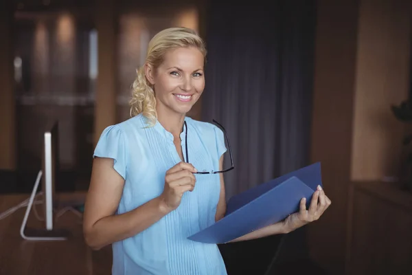 Sorrindo executivo de pé com arquivo — Fotografia de Stock