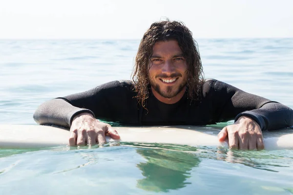 Surfer lutande på surfbräda i havet — Stockfoto