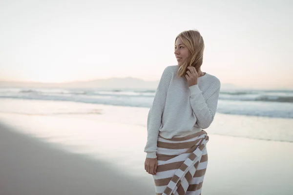 Ragionevole donna guardando lontano mentre in spiaggia — Foto Stock