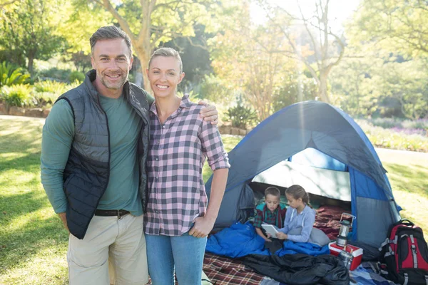 Paar glimlachend in de camera terwijl de kinderen in de tent — Stockfoto