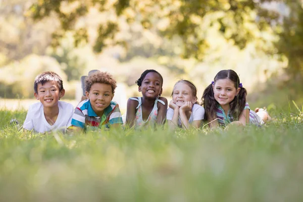 Friends resting on grass in forest Stock Photo