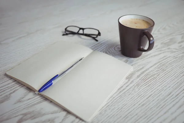 Stylo et livre avec tasse à café sur la table — Photo