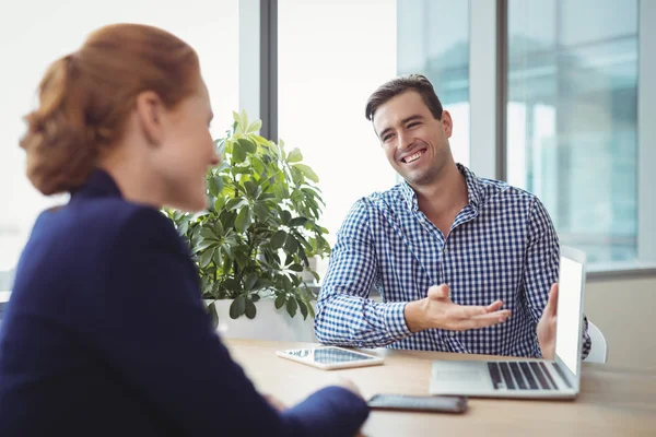 Ejecutivos discutiendo sobre portátil en el escritorio — Foto de Stock