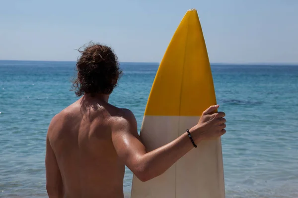 Surfista con tavola da surf guardando il mare — Foto Stock